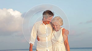 Senior Couple Walking On Beautiful Beach