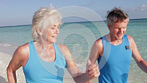 Senior Couple Walking On Beautiful Beach