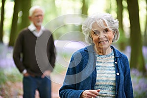 Senior Couple Walking Through Bluebell Woods