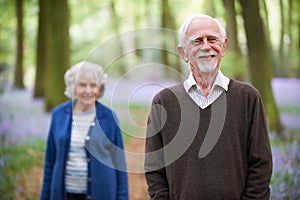 Senior Couple Walking Through Bluebells Woods