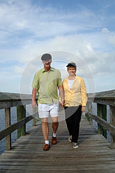 Senior couple walking on boardwalk photo