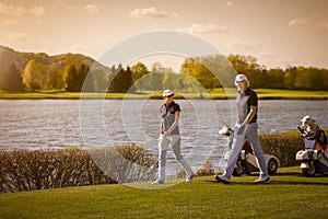 Senior couple walking on golf course.