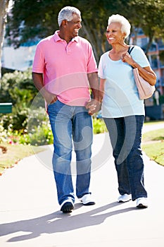 Senior Couple Walking In Park Together