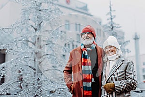 Senior couple walking in winter city center.