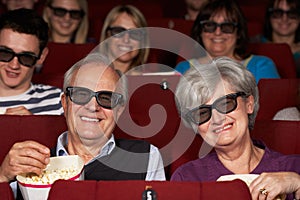 Senior Couple Watching 3D Film In Cinema