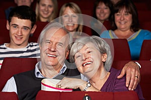 Senior Couple Watching Film In Cinema