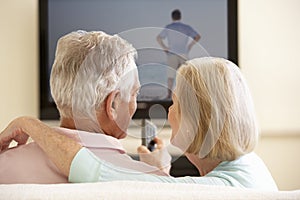 Senior Couple Watching Widescreen TV At Home photo