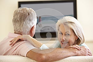 Senior Couple Watching Widescreen TV At Home photo
