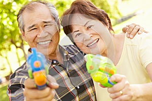 Senior couple with water pistols