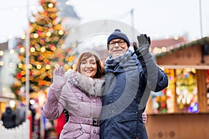 Senior couple waving hands at christmas market