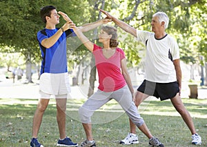 Senior Couple Working With Personal Trainer In Park