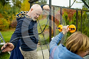 Senior couple working on a project in their garden. Man and woman constructing a greenhouse in their backyard