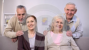Senior couples hugging and smiling on camera, family portrait, togetherness