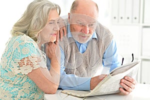Senior couples reading newspaper