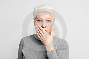 Senior covering mouth in shock or surprise