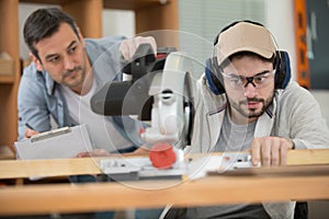 senior craftsman master with young carpenter apprentice