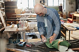 Senior craftsman refurbishing furniture in workshop