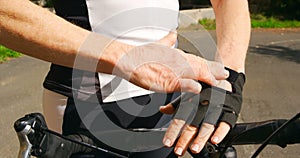 Senior cyclist wearing fingerless gloves at countryside 4k