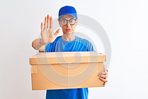 Senior deliverywoman wearing cap and glasses holding box over isolated white background with open hand doing stop sign with