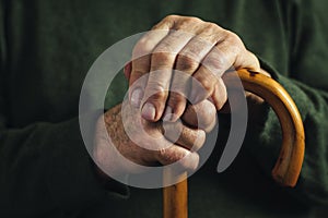 Senior disabled man clasping his walking stick