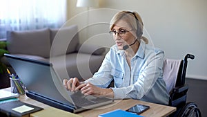 Senior disabled woman in headset applying for job from home, video conference