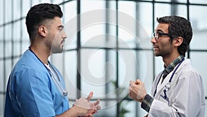 Senior doctor cheerfully talking to his colleague