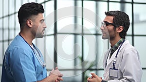 Senior doctor cheerfully talking to his colleague