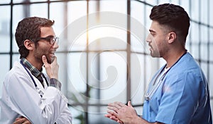 Senior doctor cheerfully talking to his colleague