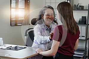 Senior Doctor and her patient. Doctor giving advice to a female patient at hospital