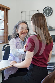 Senior Doctor and her patient. Doctor giving advice to a female patient at hospital