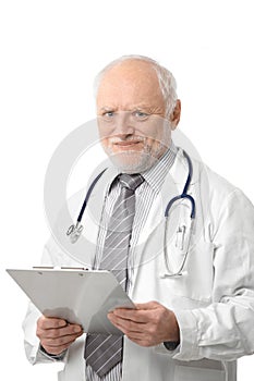 Senior doctor holding papers smiling