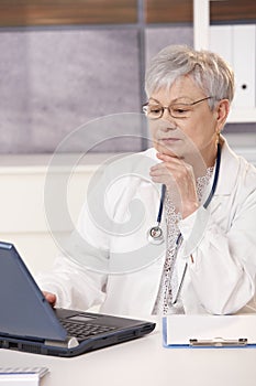 Senior doctor looking at computer