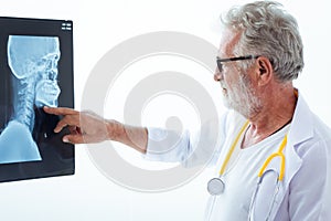 Senior doctor looking film x-ray