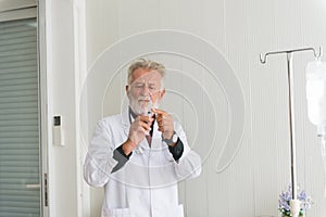 Senior doctor man prepare giving vaccine with injection or syringe to scared patient at hospital