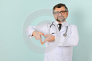 Senior doctor man wearing stethoscope and medical coat oveer blue background