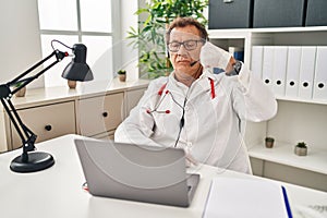 Senior doctor man working on online appointment strong person showing arm muscle, confident and proud of power