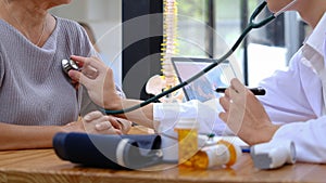 Senior doctor measure blood pressure for asian woman to check her condition