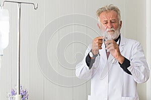 Senior doctor men prepare giving vaccine with injection or syringe to scared patient at hospital