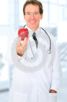 Senior Doctor Offering Red Apple To Patient