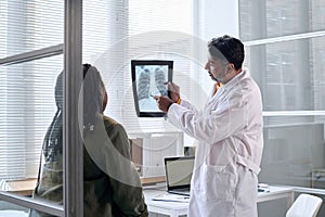 Senior Doctor Pointing at Chest X Ray