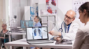 Senior doctor pointing at lungs x-ray