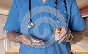 Senior doctor in scrubs with Oxycodone tablets