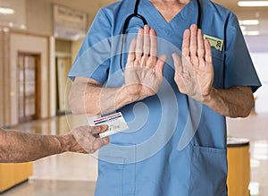 Senior doctor in scrubs refusing Medicare Card