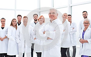 Senior doctor standing in front of a group of medical staff.