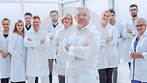 senior doctor standing in front of a group of medical staff.