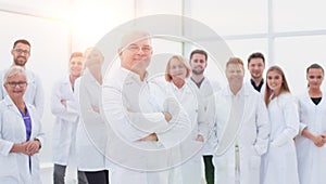 senior doctor standing in front of a group of medical staff.