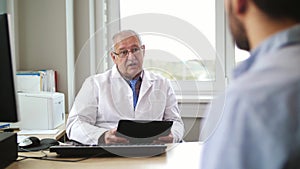 Senior doctor talking to male patient at hospital