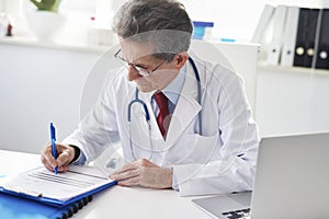 Senior man working in his doctorÃ¢â¬â¢s office photo