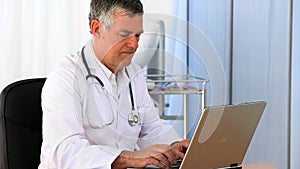 Senior doctor working on his laptop