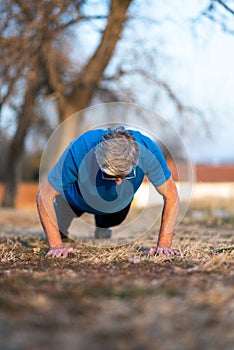 Senior doing pushups on outdoor workout